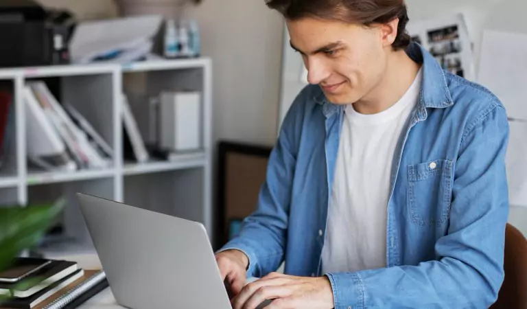 young man working on a computer inside of a house